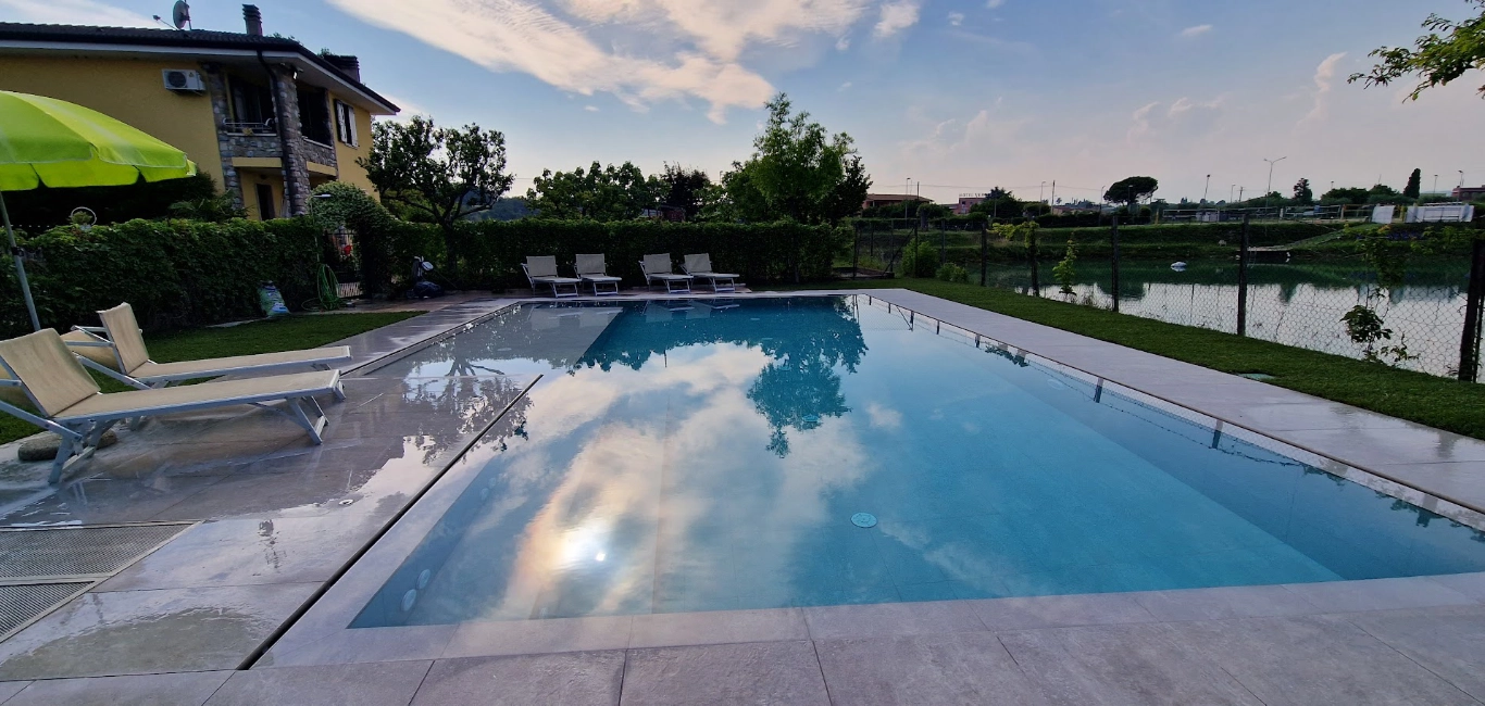 Piscina all'aperto con lettini e giardino