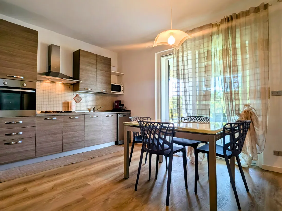 Cucina moderna con tavolo e sedie grigie.