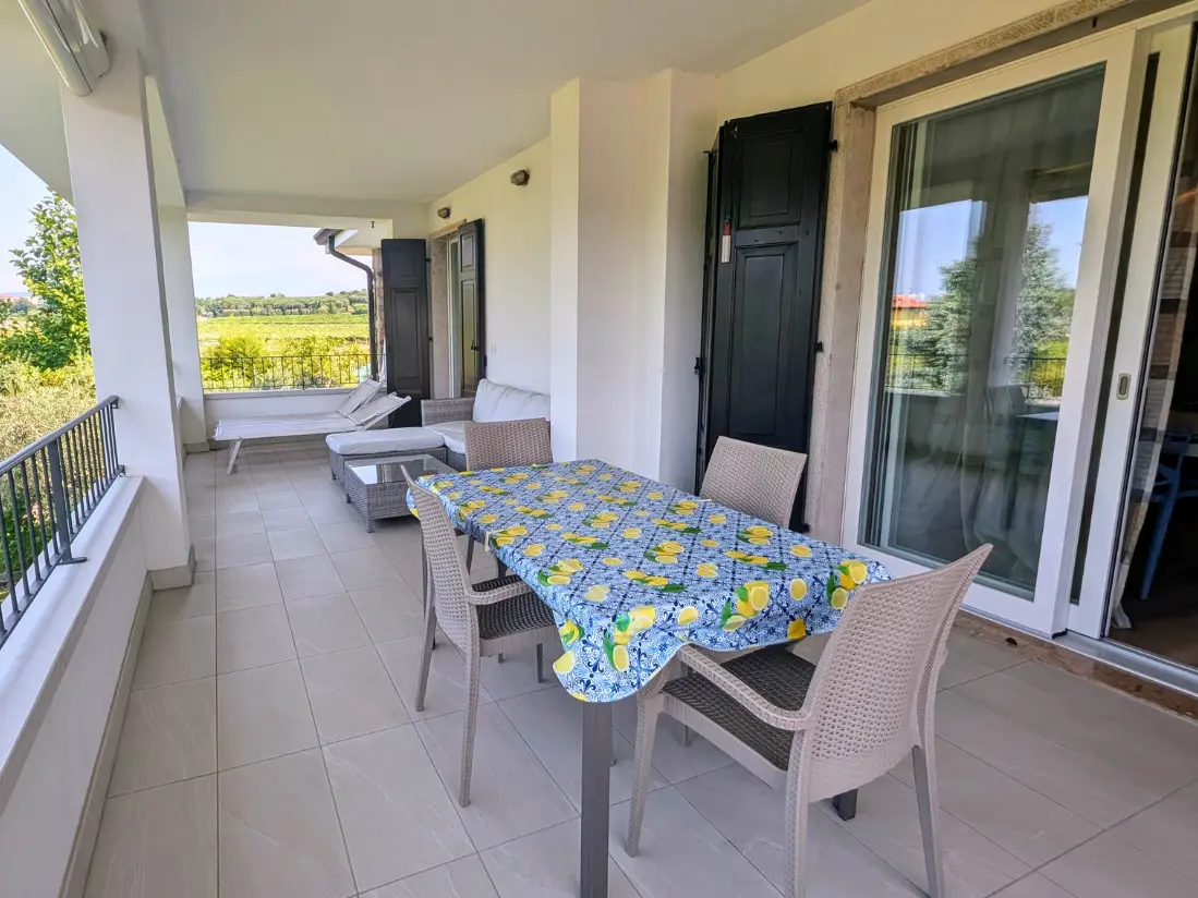 Terrazza con tavolo e sedie, vista campagna italiana.