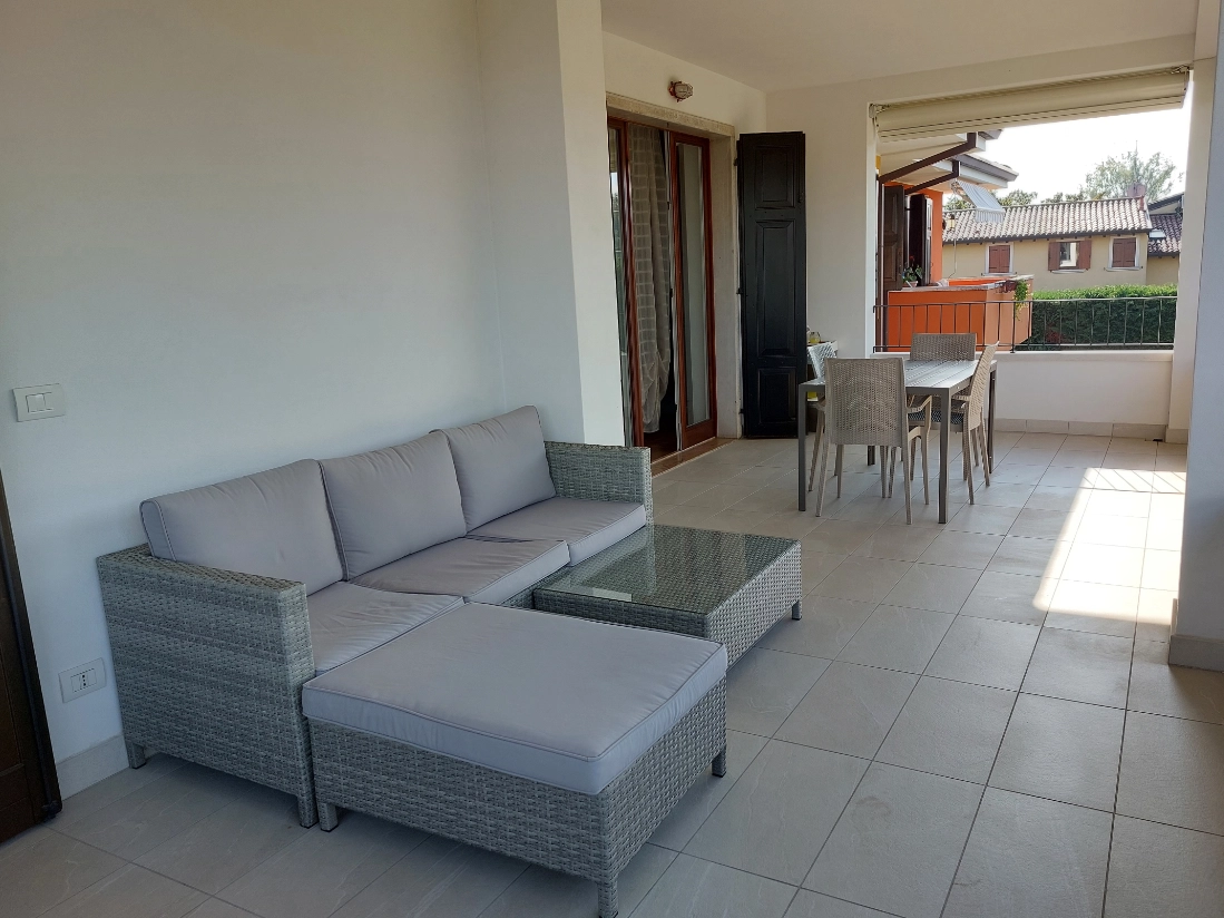 Terrazza con divano e tavolo da pranzo all'aperto.