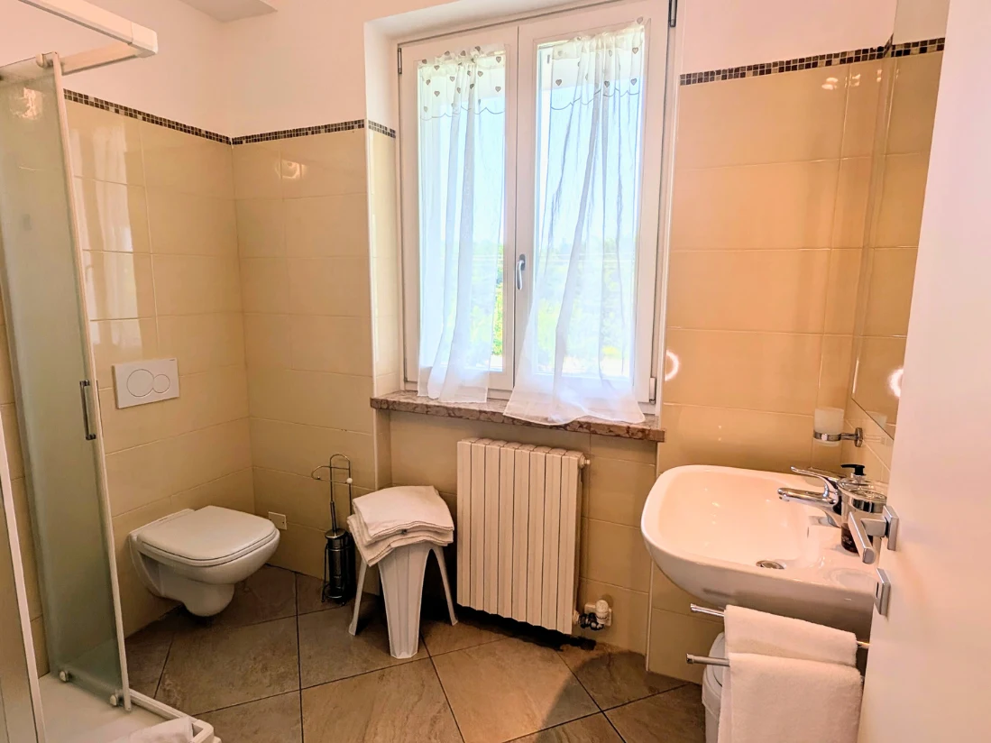 Bagno luminoso con finestra e doccia.