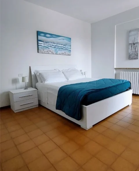 Camera da letto moderna con arredamento bianco.