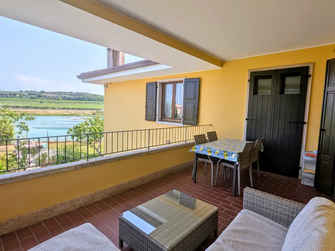 Terrazza soleggiata con tavolo, sedie e vista.