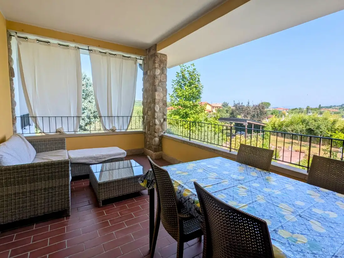 Veranda con mobili in vimini e vista panoramica.